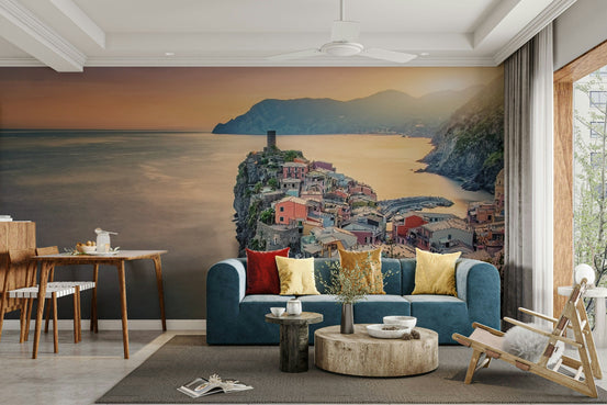 Cliffside Village Dream wallpaper mural of a clifftop village behind a teal sofa with red and yellow cushions