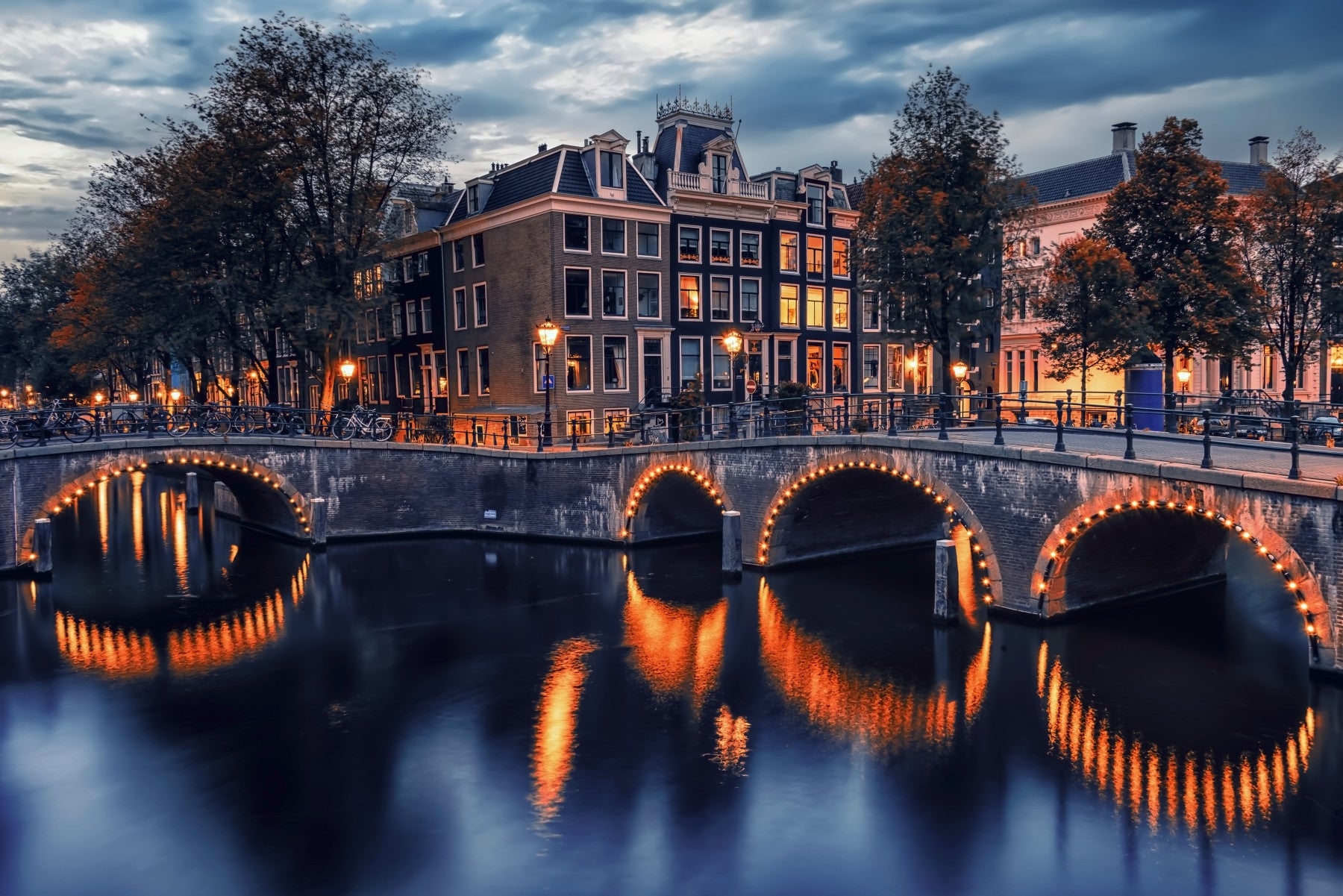 Amsterdam Nights mural featuring glowing arched bridge reflections.