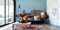 London Luminescence wallpaper mural of the glowing skyline above a navy velvet sofa with orange pillows in a loft
