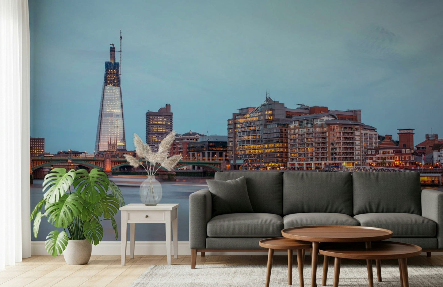 London Luminescence wallpaper mural of The Shard skyline behind a dark grey sofa and monstera in a living room