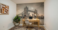 London's Tower Bridge wallpaper mural in sepia in a home office with a wood desk and brass lamp