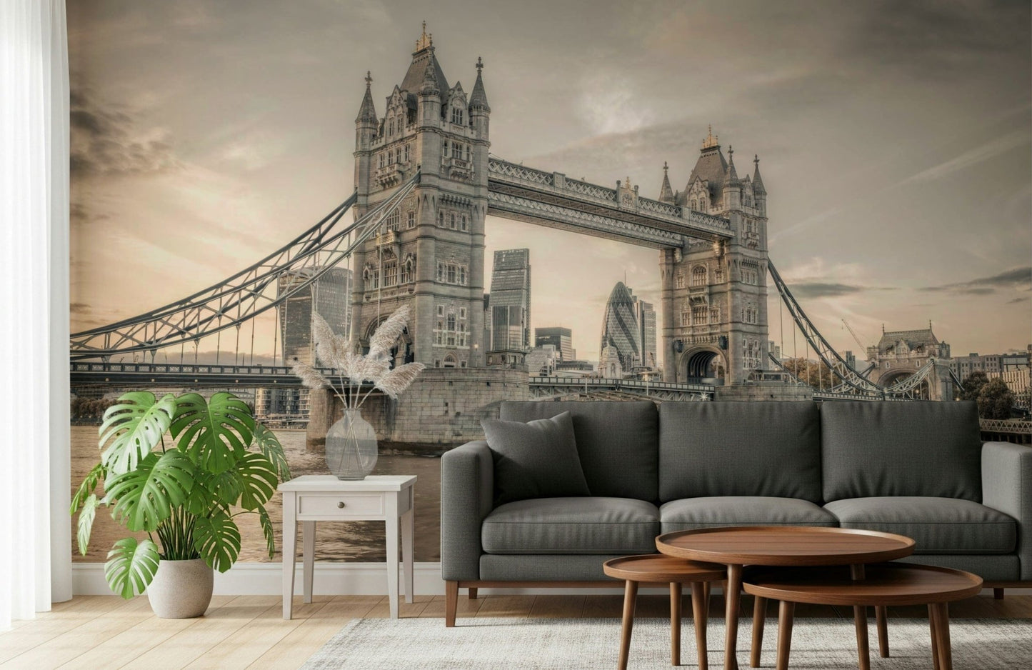 London's Tower Bridge wallpaper mural in sepia behind a dark grey sofa with a big monstera plant