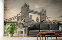 London's Tower Bridge wallpaper mural in sepia behind a dark grey sofa with a big monstera plant