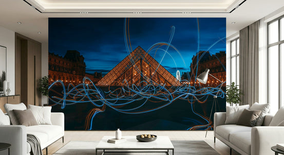 Illuminated Louvre wallpaper mural of the lit glass pyramid with blue light trails behind white sofas in a living room