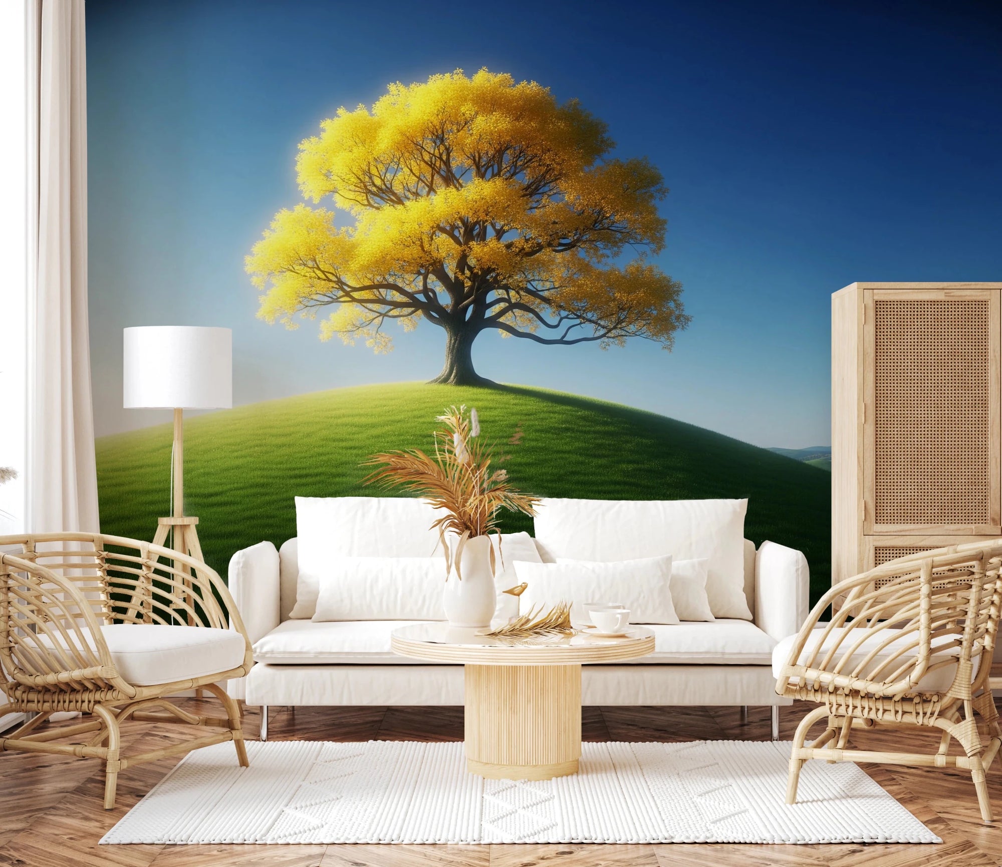 Lucent Tree wallpaper mural of a golden tree on a green hill under blue sky behind a white sofa and rattan chairs in a living room