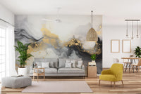 Luxurious Black and Gold Abstract Marble wallpaper mural with gold splatter behind a grey sofa and yellow armchair in a living room