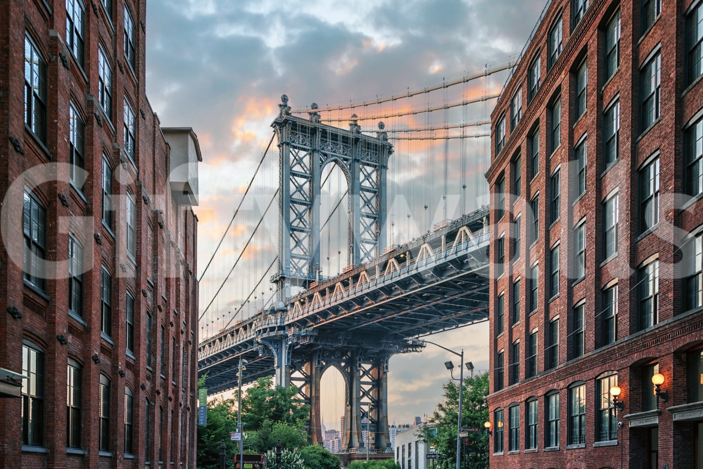Manhattan Bridge Vista wallpaper mural shown as a full-wall scene of the blue bridge tower framed by brick buildings at sunset