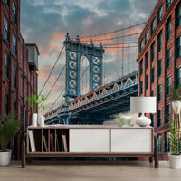 Manhattan Bridge Vista wallpaper mural of the blue bridge and brick buildings above a wood sideboard and lamp