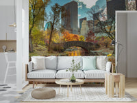 Manhattan's Autumn Embrace wallpaper mural of an autumn park and skyline behind a white sofa in a living room