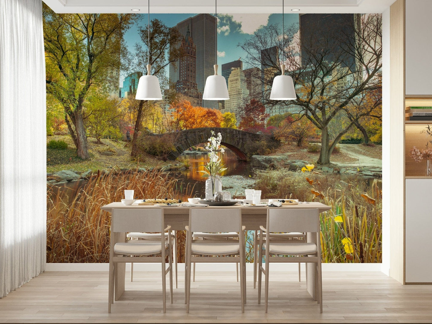 Manhattan's Autumn Embrace wallpaper mural of an autumn park behind a wood dining table and white pendant lights