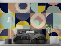 Mescolanza Alt V3 wallpaper mural in navy and yellow geometric pattern behind a grey velvet bed in a modern bedroom