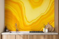 Metallic yellow Color flow wallpaper mural styled as a feature wall behind a dining table and chairs in yellow tones