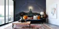Wallpaper depicting a lighthouse with beams of light reaching across a celestial night sky.