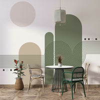 Minimalist Desert Vibes wallpaper mural in green and beige behind a white round table and rattan chairs in a dining nook