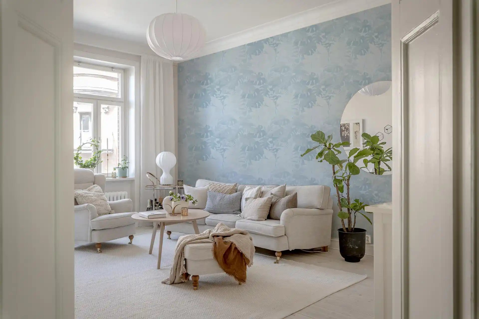 Pale blue botanical wallpaper with monstera leaf shapes