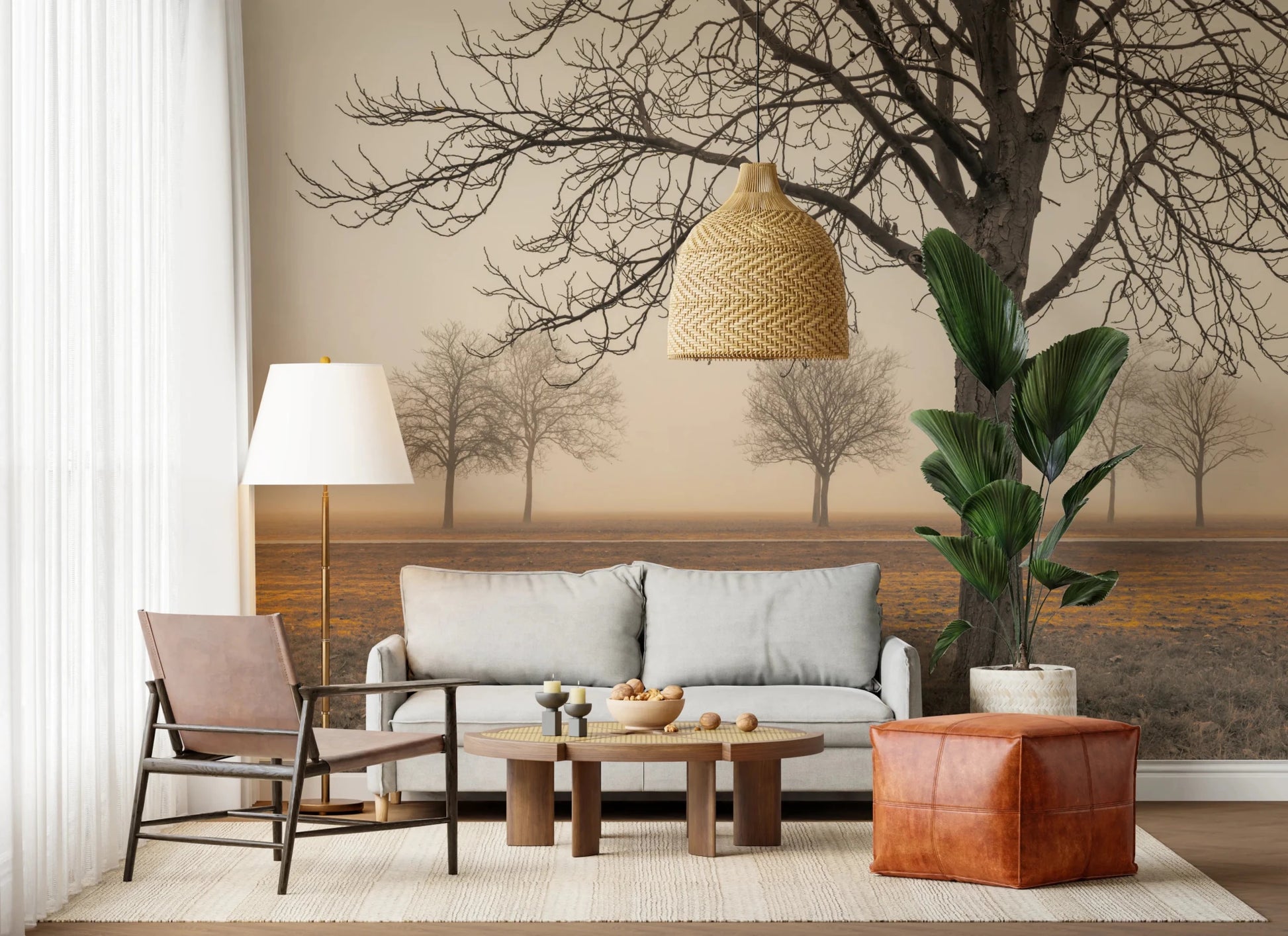 Misty Countryside wallpaper mural with hazy autumn trees above a grey sofa and brown leather armchair in a living room