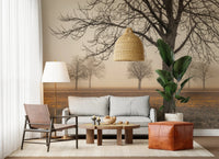 Misty Countryside wallpaper mural with hazy autumn trees above a grey sofa and brown leather armchair in a living room