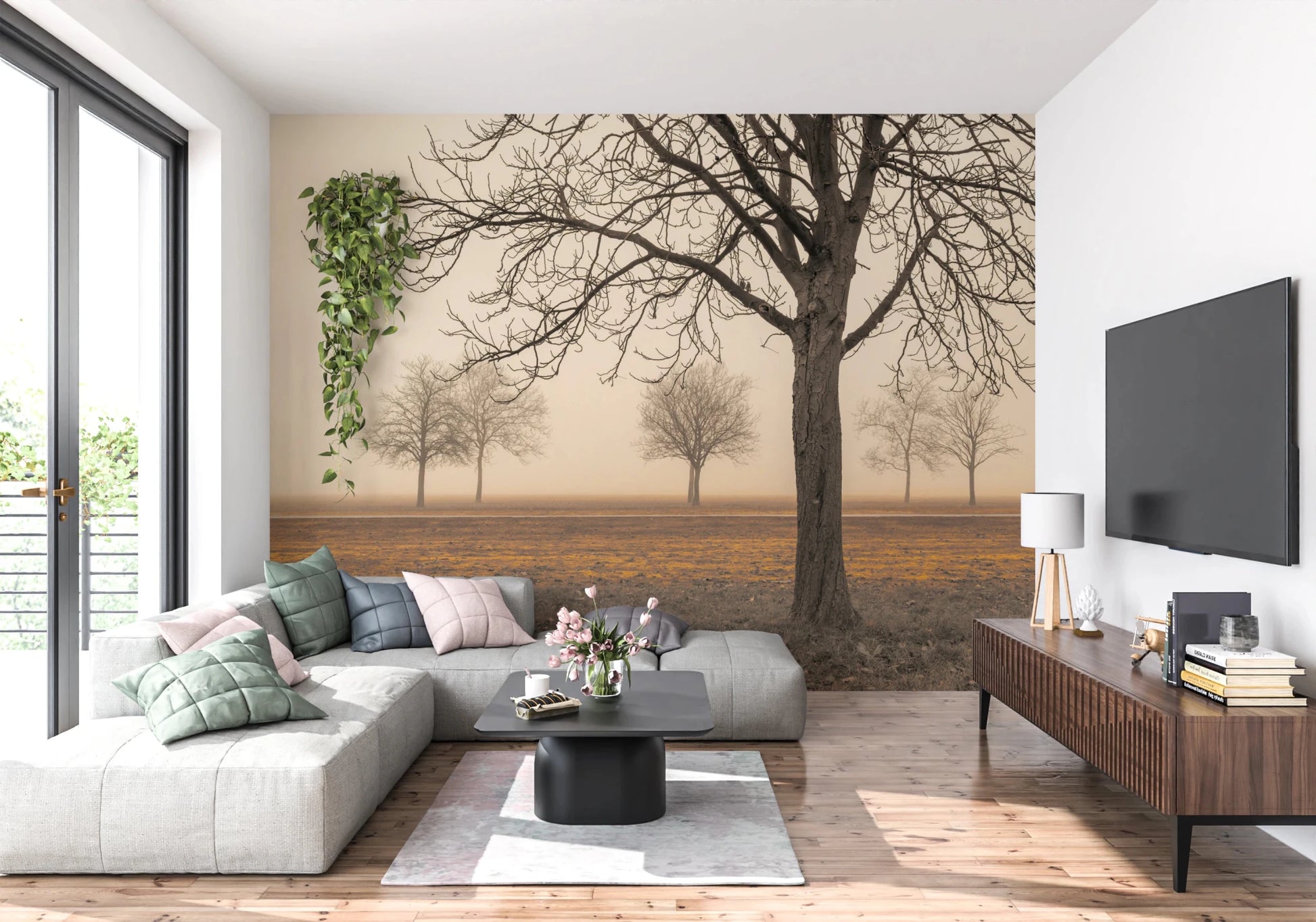 Misty Countryside wallpaper mural with bare sepia trees in fog behind a grey sectional sofa in a living room