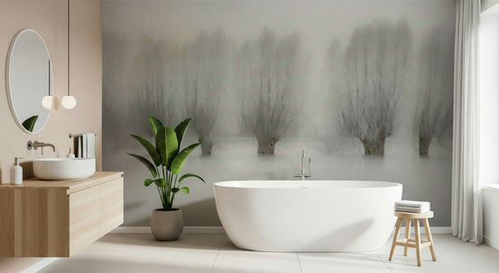 Misty Grove Serenity wallpaper mural of foggy bare trees over water behind a white freestanding tub and round mirror in a bathroom