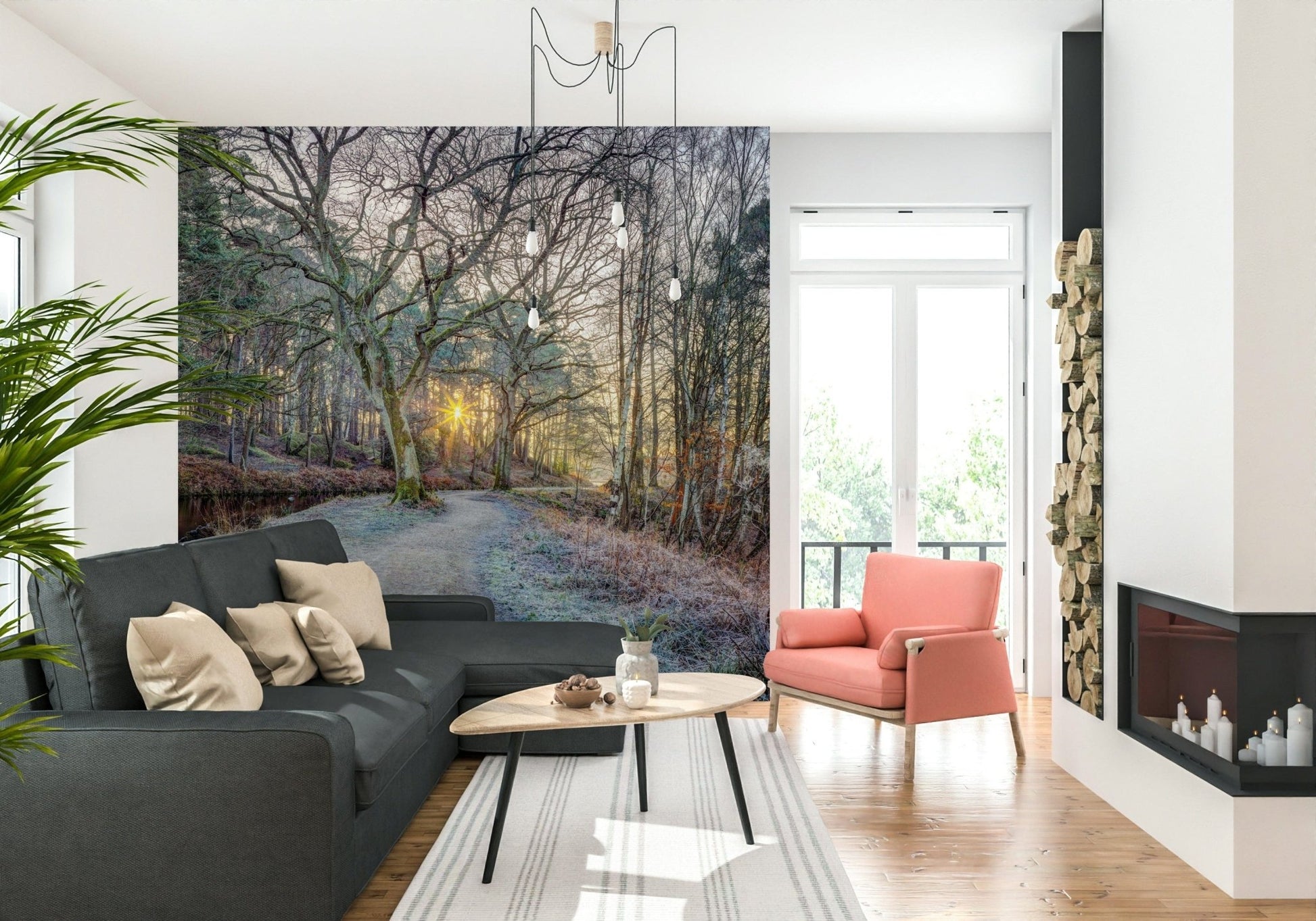 Misty Woodland Glare mural with a dark grey sectional and coral armchair beside stacked firewood and a fireplace