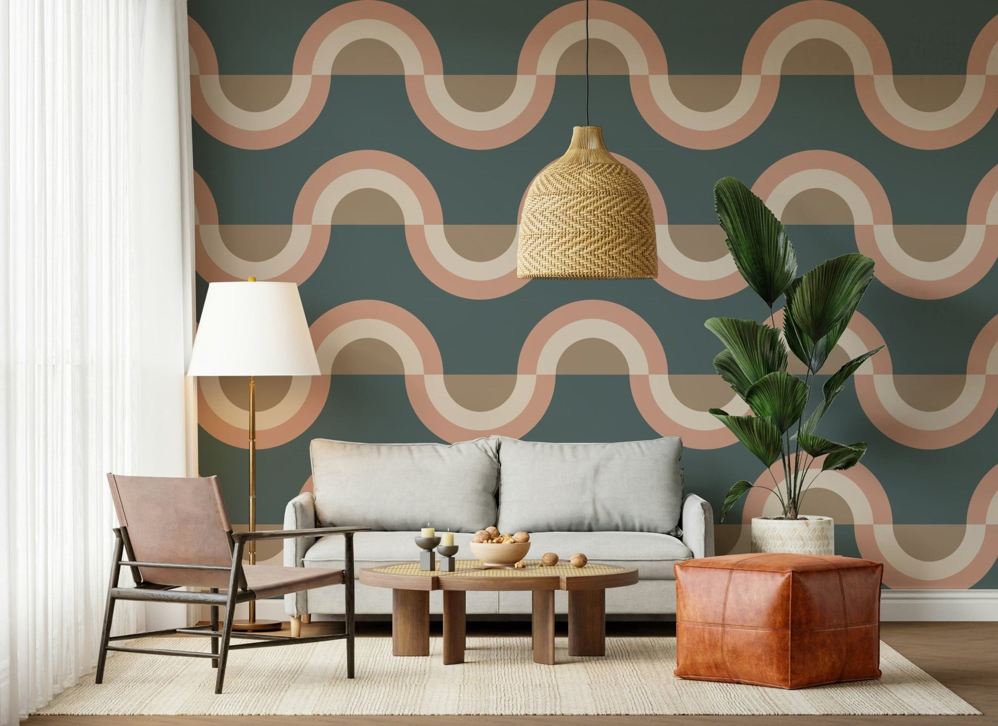 Modern Retro Arcs Decor wallpaper mural in teal and terracotta behind a grey sofa, woven pendant and leather pouf in a living room