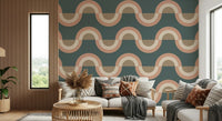 Modern Retro Arcs Decor wallpaper mural with teal and terracotta waves behind a cream sofa and rattan table in a living room