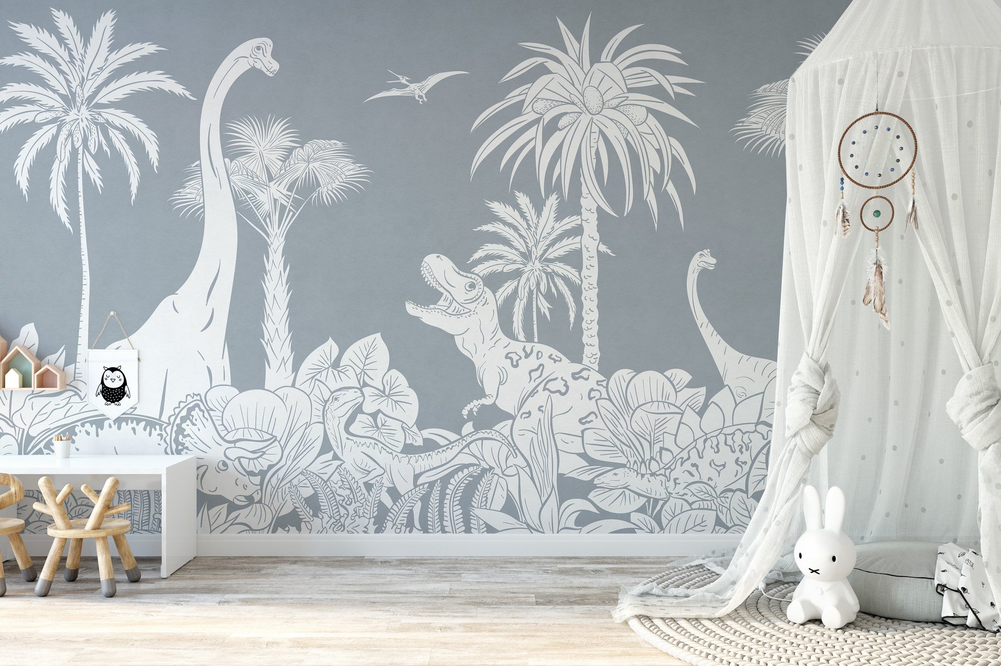 Monochrome Dino Blue wallpaper mural with grey dinosaurs and palm trees in a kids room with white canopy and bunny toy