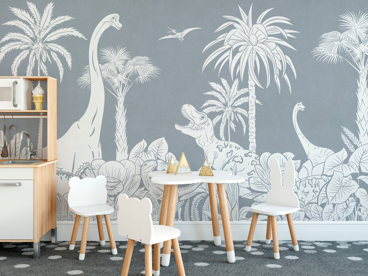 Monochrome Dino Blue wallpaper mural of grey line-art dinosaurs and palms behind a playroom table and white bear-ear chairs