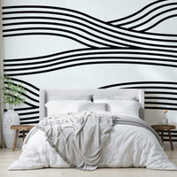 Black and white wave mural with rhythmic, flowing curves.

