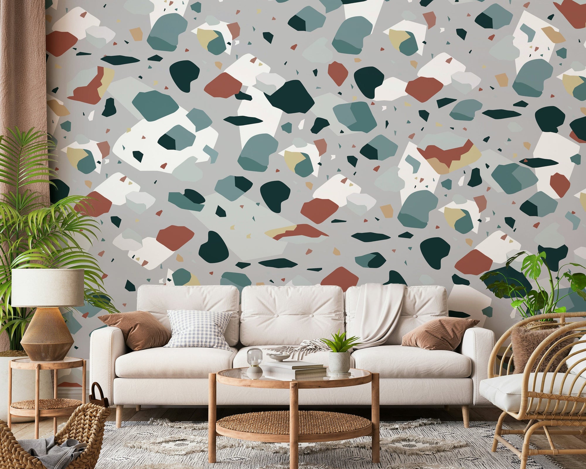 Fragment Fusion wallpaper mural with teal and terracotta terrazzo shapes on grey behind a cream sofa in a living room