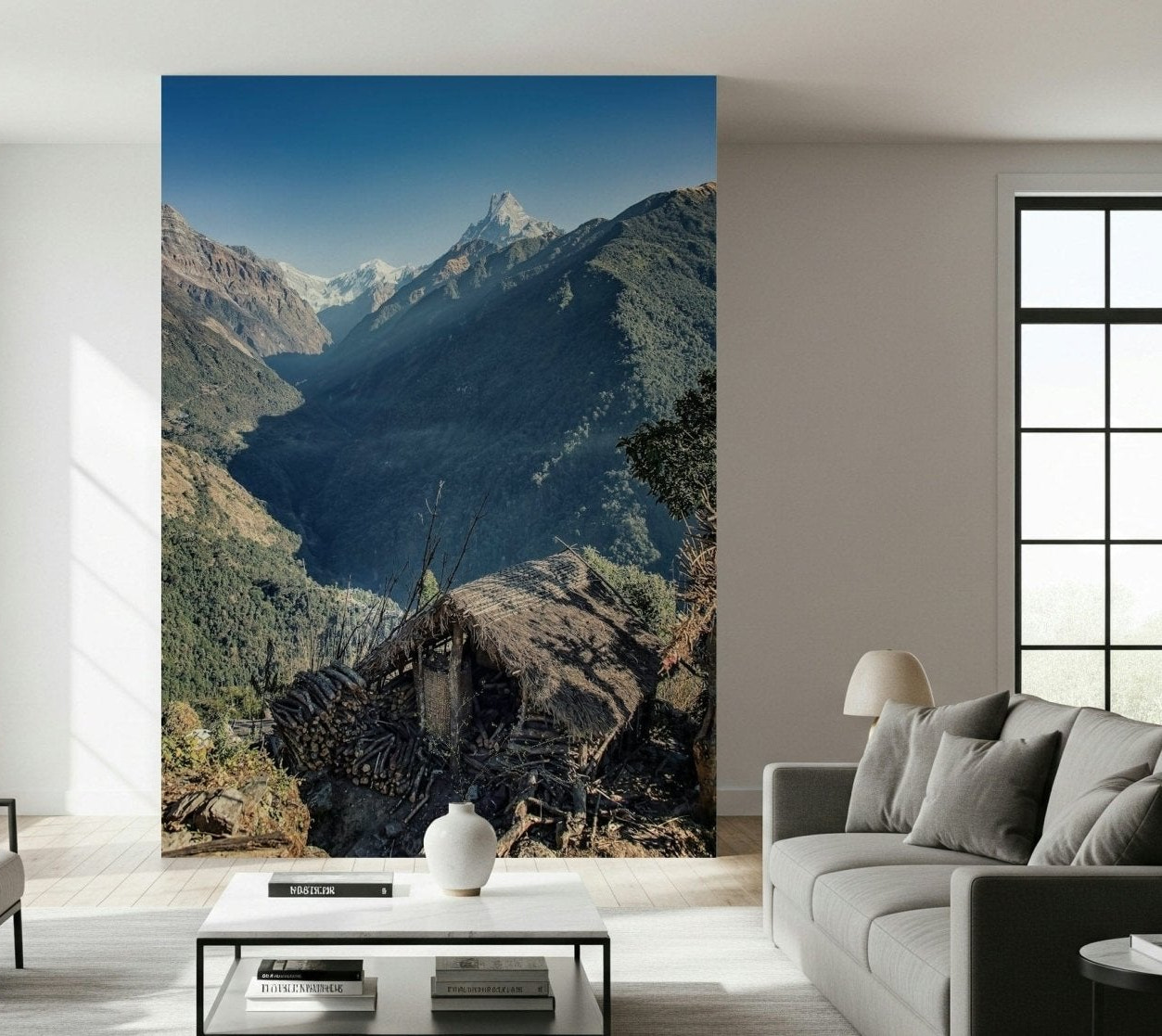 Scenic mountain mural with a thatched hut set against steep forested slopes and distant snow-capped peaks.