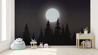 Mystical Moonlit Forest wallpaper with glowing moon and black pines in a nursery with a mint beanbag and plush toys