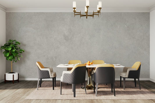 Natural Subtle Concrete wallpaper mural in a dining room with yellow and grey chairs under a brass chandelier