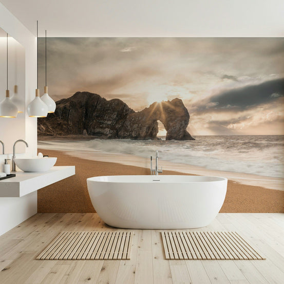 Nature's Gateway wallpaper mural of a sunset sea arch in a bathroom behind a freestanding white bathtub