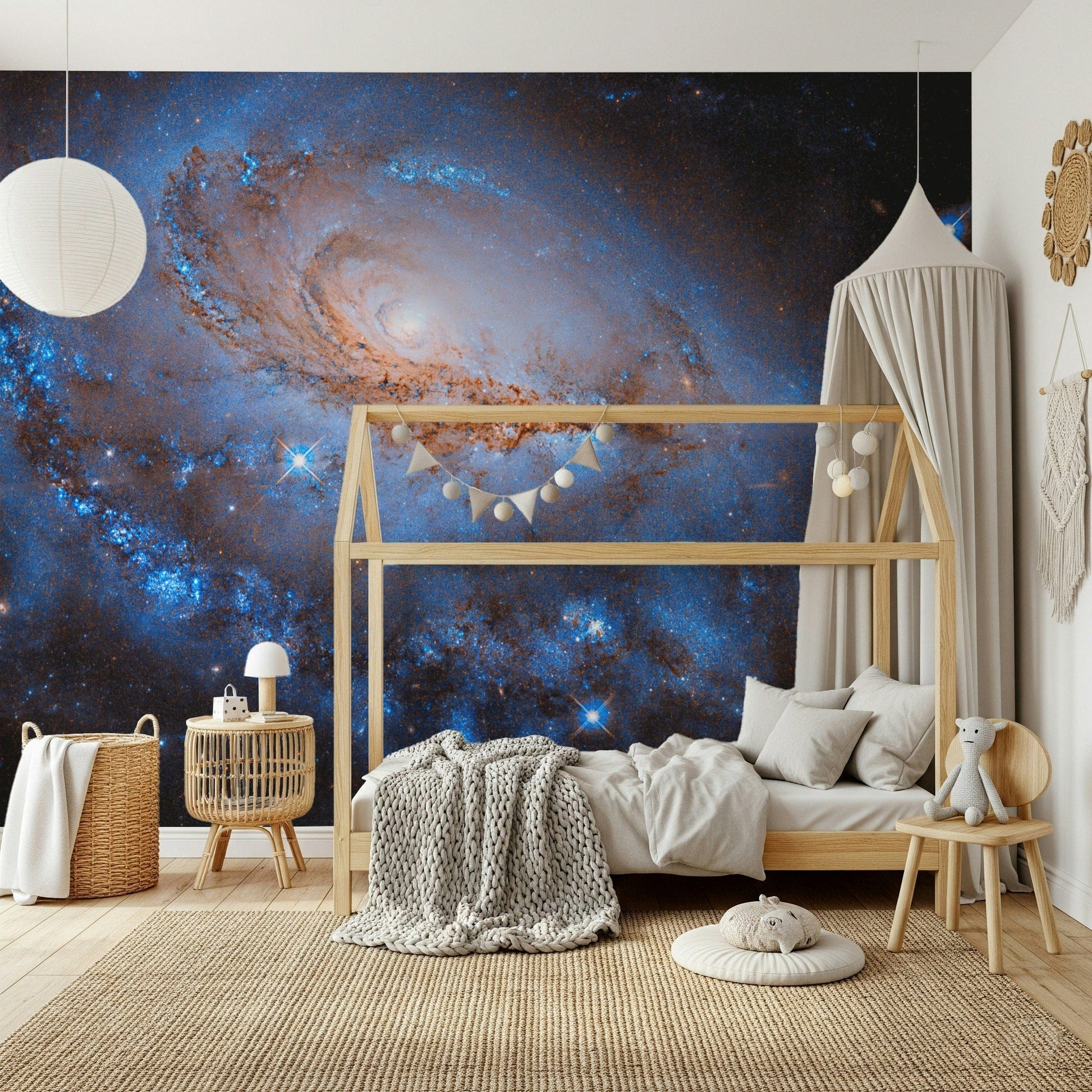 Nebula Dreams wall mural of a spiral galaxy behind a wood house-frame bed with a canopy in a kids room
