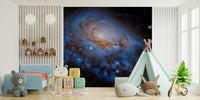 Nebula Dreams wall mural of a blue galaxy behind a toddler bed and teepee tent in a bright playroom