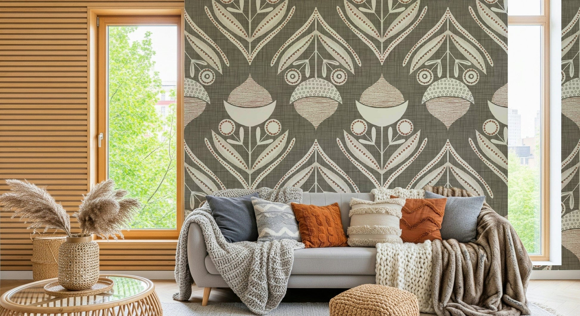 Stylized botanical pattern with symmetrical blooms and curved leaves in muted tones over a textured gray base
