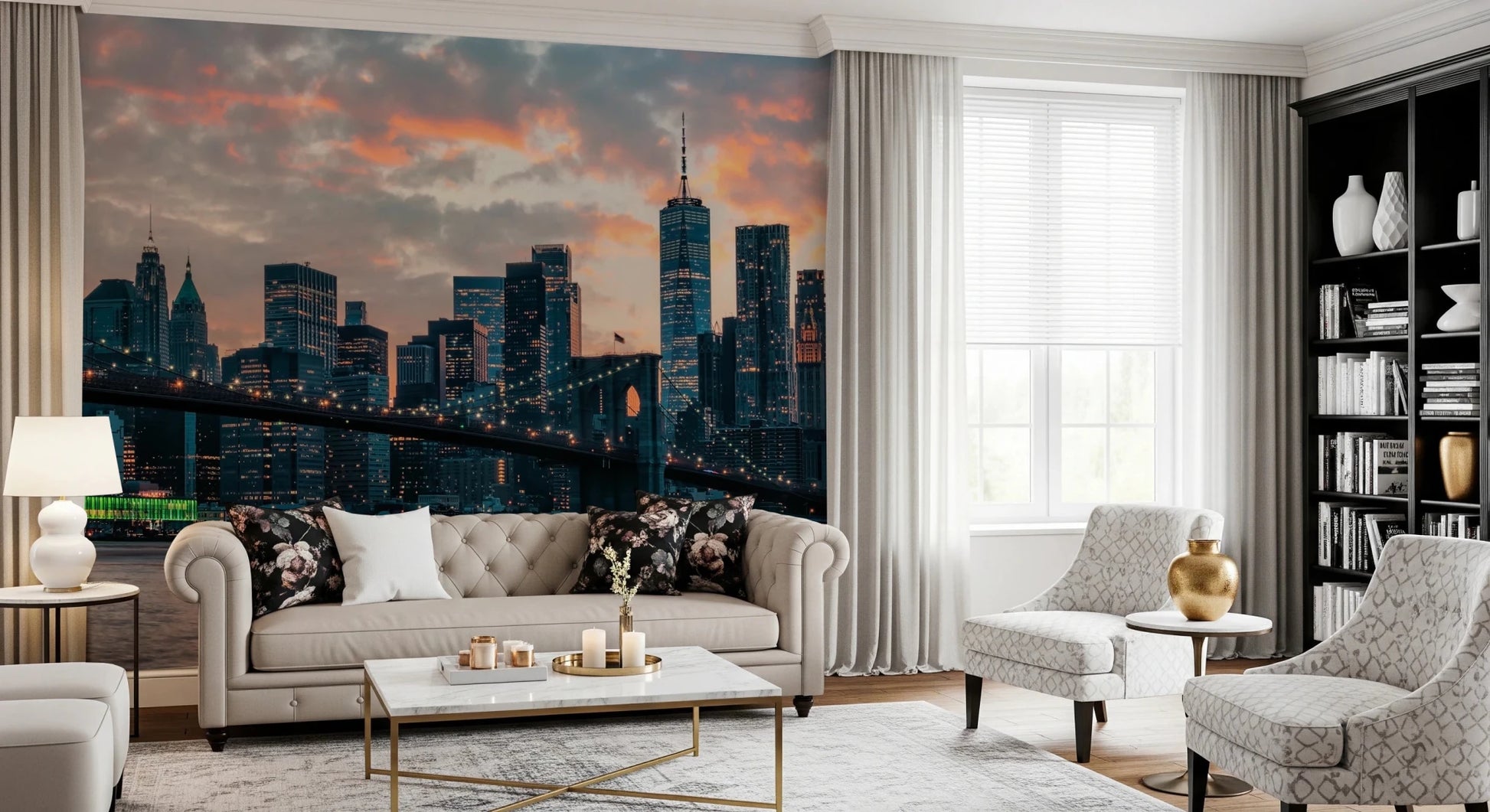 New York In The Evening wallpaper mural of the skyline behind a tufted cream sofa with floral pillows and bookcase