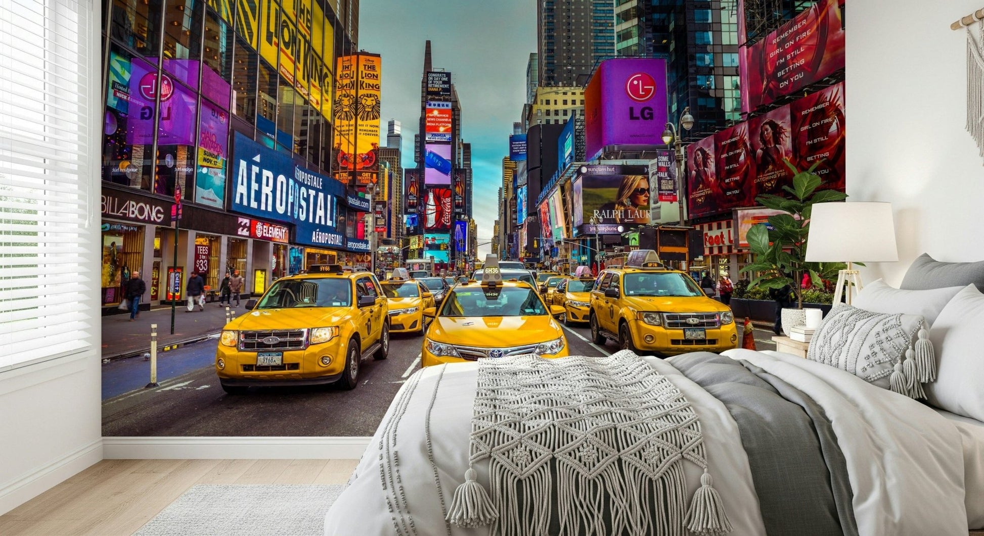 New York's Urban Pulse mural of Times Square cabs behind a bed with white macrame-trimmed bedding