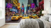 New York's Urban Pulse mural of Times Square cabs behind a bed with white macrame-trimmed bedding