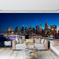 Night Metropolis wallpaper mural with Manhattan skyline and bridge over the East River behind a beige sofa in a living room