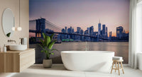 NYC Bridge at Dusk wallpaper mural of the Brooklyn Bridge at twilight behind a freestanding white bathtub in a bathroom