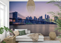NYC Bridge at Dusk wallpaper mural of the dusk skyline behind a white chaise daybed in a plant-filled living room