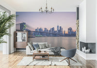 NYC Bridge at Dusk wallpaper mural of the dusk skyline behind a white sofa and grey swivel chair in a living room