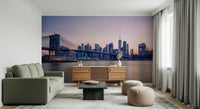 NYC Bridge at Dusk wallpaper mural of the bridge at dusk behind a green sofa and wood sideboard in a living room