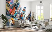 NYC Buzz wallpaper mural with a yellow taxi and Times Square screens behind a white sofa and wire chair in a living room