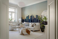 NYC Skyline at Dawn wallpaper mural of the hazy dawn skyline behind a cream sofa in a Scandinavian living room