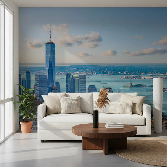 NYC Skyline Majesty wallpaper mural of Manhattan and the harbor behind a white sofa in a bright living room