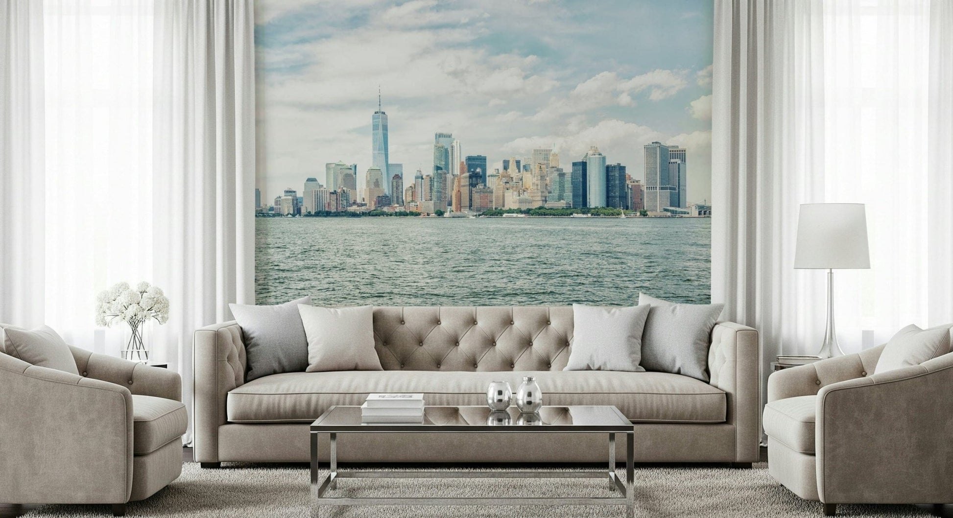NYC Skyline View wallpaper mural of Manhattan across the harbor behind a beige tufted sofa and armchairs in a living room
