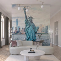 NYC's Lady Liberty wallpaper mural of the Statue of Liberty behind a curved cream boucle sofa and marble table in a living room